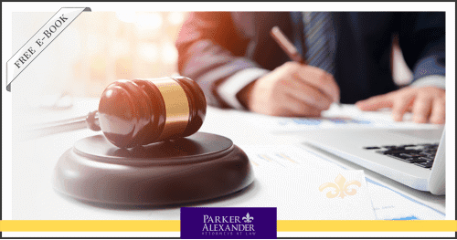 Person writing something at a desk that has a gavel on it